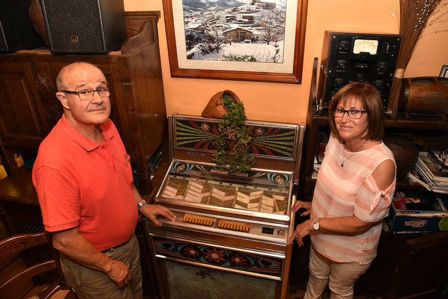 José Luis Gracia y Encarna Colmenar, junto a la máquina de música del bar 'El picaporte', en el centro histórico de la localidad cacereña.