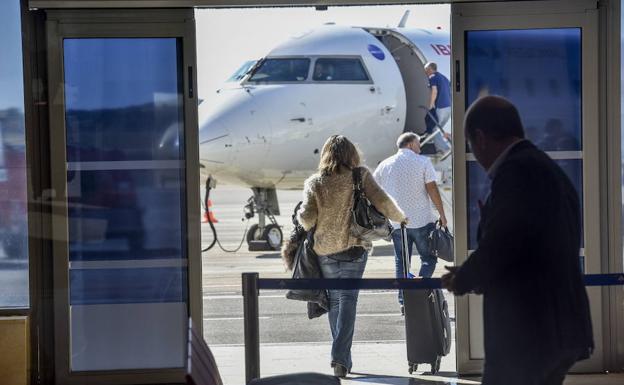 Dos usuarios del aeropuerto extremeño se dirigen a un avión en una ruta operada por Air Nostrum.