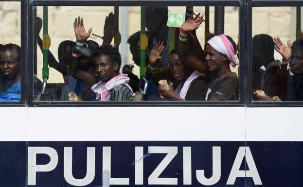 Migrantes en un autobús policial tras desembarcar en el puerto La Valeta en Malta. 