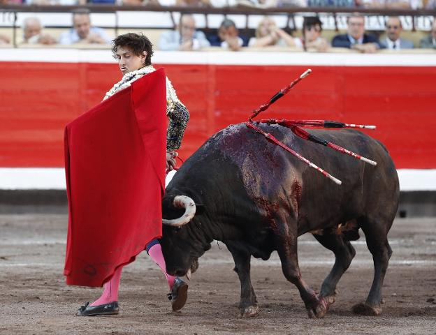 Habitual pase por la espalda del peruano Roca Rey al primero de sus toros de ayer en Bilbao. :: efe