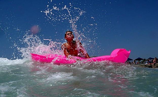 Un joven se baña en la playa de Puerto Banús. 