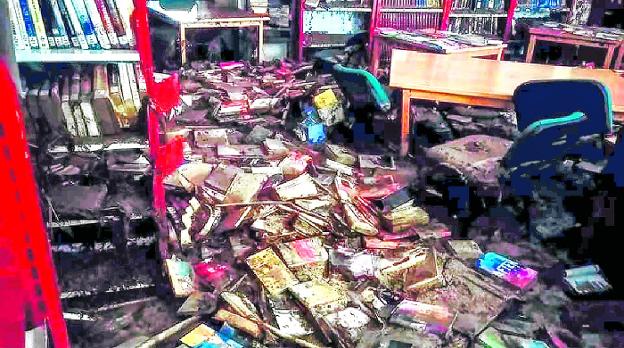 Así dejó la riada las estanterías de la biblioteca pública de Cebolla. El lodo ha echado a perder diez mil libros. :: R. C.