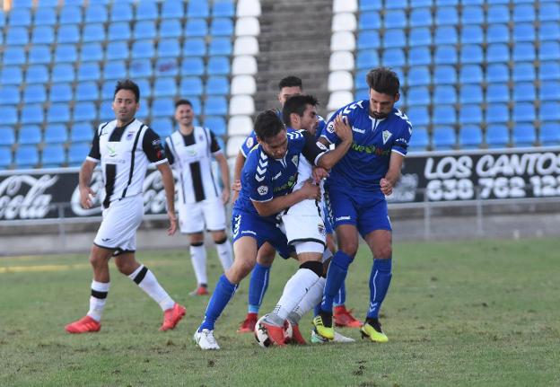 El blanquinegro David Martín, presionado por dos jugadores del Marbella. :: CASIMIRO MORENO