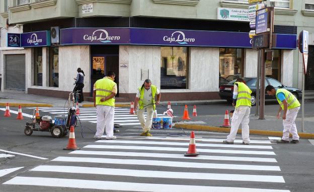 Operarios pintando un paso de cebra de la ciudad. :: mam