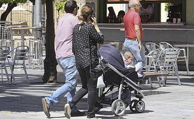 Una pareja paseando con su bebé por Mérida. :: 