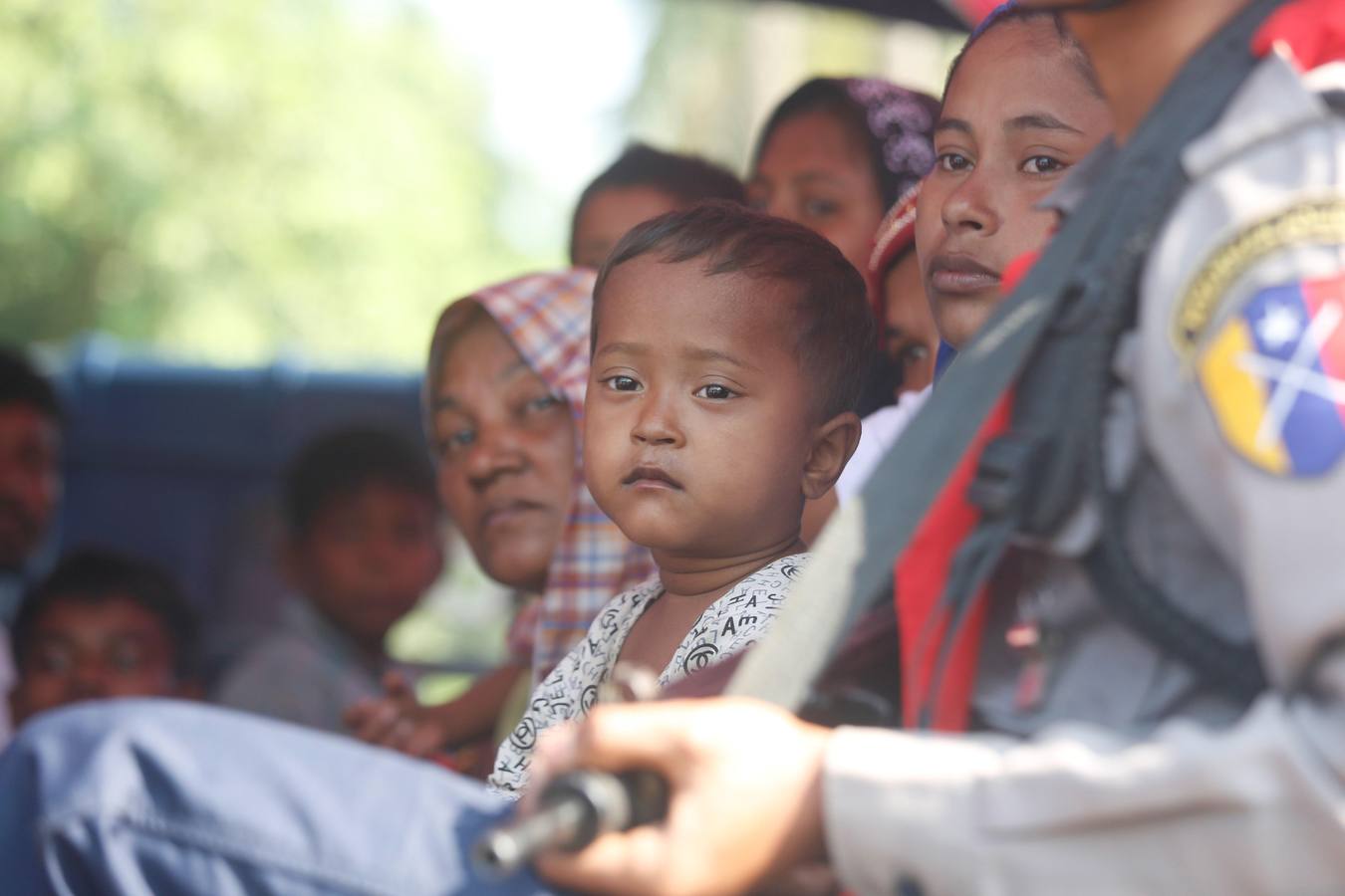 Policías birmanos escoltan al grupo de 106 rohinyás de vuelta a Sittwe en el estado de Rakáin (Birmania). El pasado 16 de noviembre, el barco en el que viajaban los 106 rohinyás encalló en la costa cerca de Rangún, con uno de sus ocupantes muerto, cuando trataba de llegar a Malasia. 