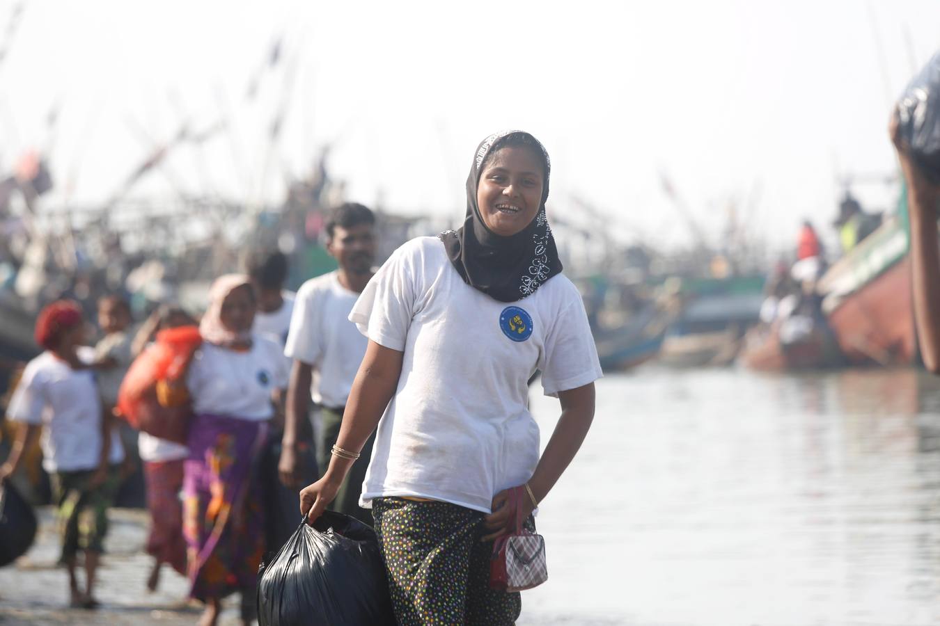 Policías birmanos escoltan al grupo de 106 rohinyás de vuelta a Sittwe en el estado de Rakáin (Birmania). El pasado 16 de noviembre, el barco en el que viajaban los 106 rohinyás encalló en la costa cerca de Rangún, con uno de sus ocupantes muerto, cuando trataba de llegar a Malasia. 