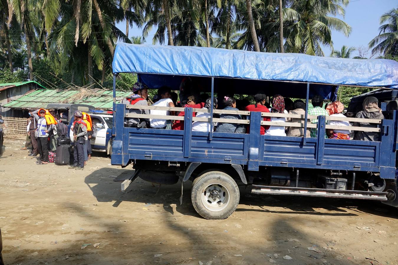 Policías birmanos escoltan al grupo de 106 rohinyás de vuelta a Sittwe en el estado de Rakáin (Birmania). El pasado 16 de noviembre, el barco en el que viajaban los 106 rohinyás encalló en la costa cerca de Rangún, con uno de sus ocupantes muerto, cuando trataba de llegar a Malasia. 