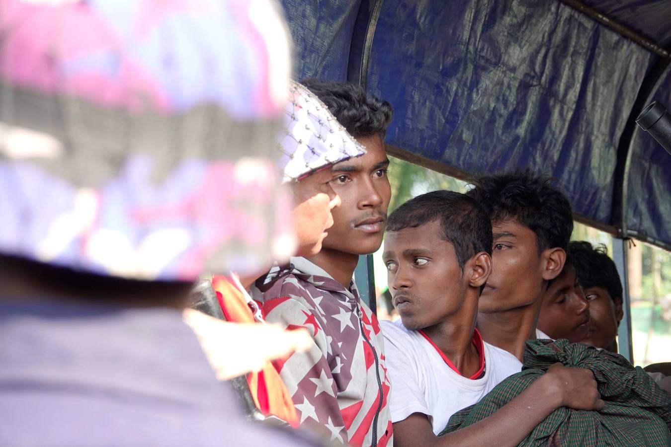 Policías birmanos escoltan al grupo de 106 rohinyás de vuelta a Sittwe en el estado de Rakáin (Birmania). El pasado 16 de noviembre, el barco en el que viajaban los 106 rohinyás encalló en la costa cerca de Rangún, con uno de sus ocupantes muerto, cuando trataba de llegar a Malasia. 