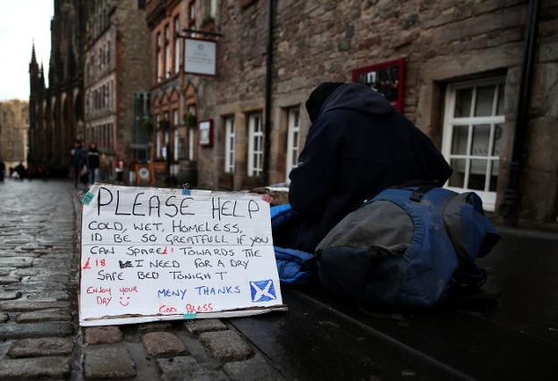 Un hombre pide ayuda en una calle de Edimburgo. Cerca de 1,5 millones de personas viven en la indigencia en Gran Bretaña. :: andrew miligan