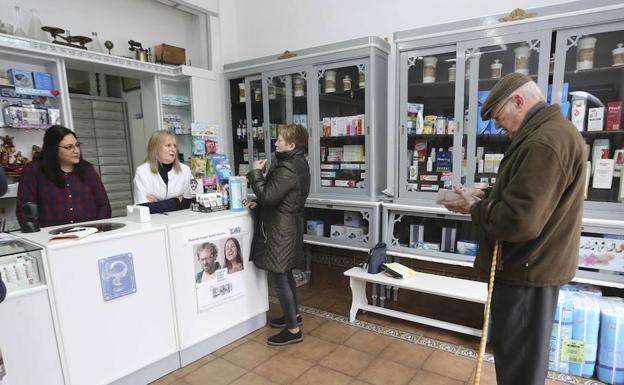 Rocío Luengo (bata blanca) es la auxiliar de la única farmacia de esta localidad de 980 vecinos. :: 