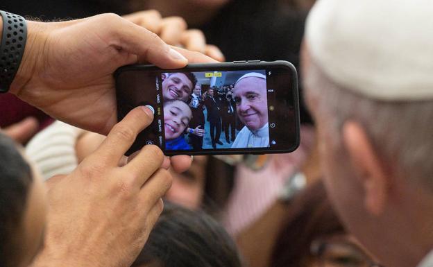 El papa Francisco, se hace un selfie con dos fieles este miércoles durante una audiencia en el Vaticano.