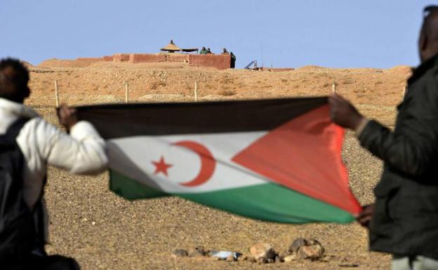 Dos saharauis sostienen una bandera del Frente Polisario. 