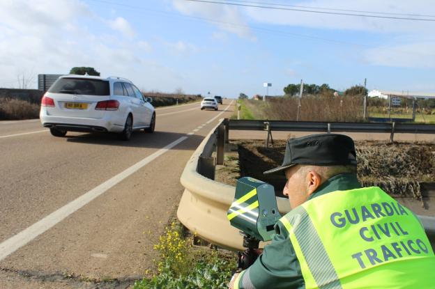Un agente sitúa el Veloláser en un guardarrail de la carretera que une Badajoz con Cáceres. :: hoy