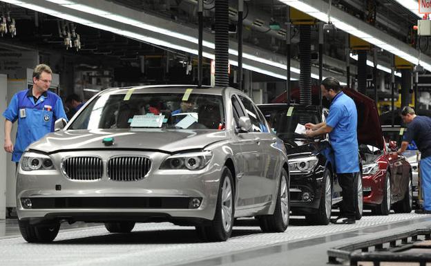 Dos empleados trabajan en una fábrica de automóviles alemana. 