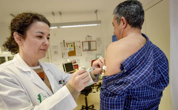 Un hombre es vacunado contra la gripe en un centro de salud de Badajoz. :: 
