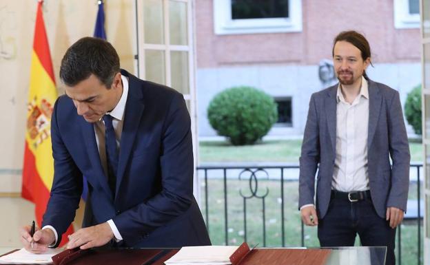 Sánchez e Iglesias firman el acuerdo presupuestario.