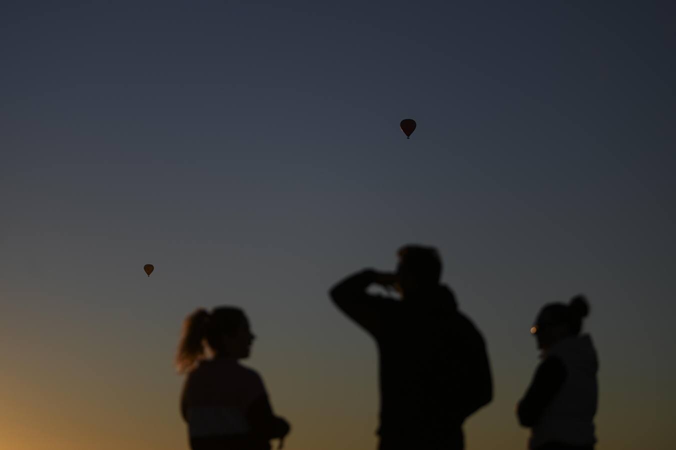 Observan cómo los globos aerostáticos se elevan sobre el lago Burley-Griffin durante el festival internacional de globos de Camberra, Australia. El festival es considerado como uno de los más grandes del mundo.
