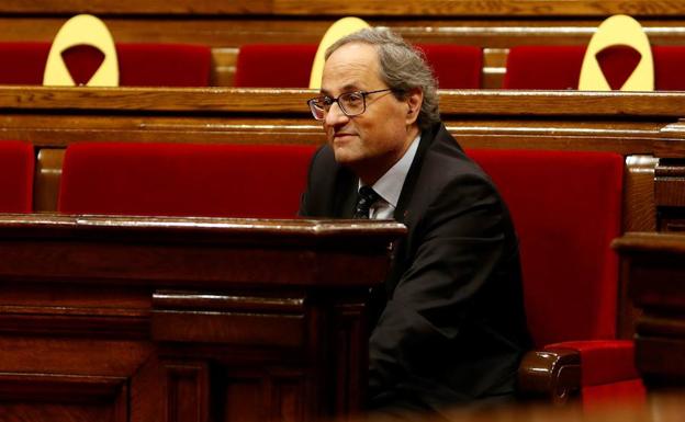 Quim Torra, durante una sesión en el Parlament rodeado de lazos amarillos.