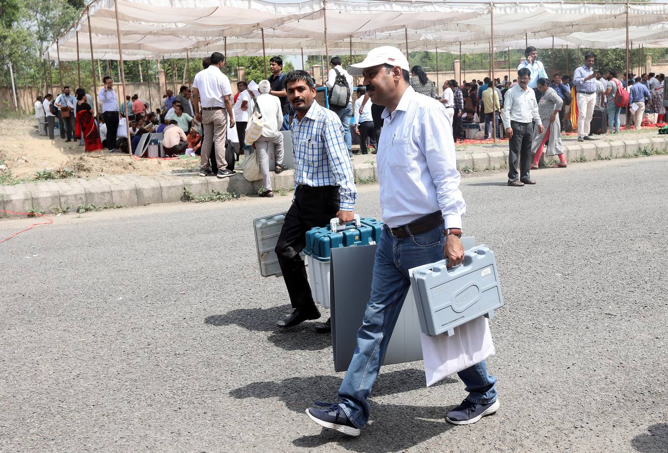 Delegados electorales reciben este miércoles las máquinas de votación un día antes del comienzo de la primera fase de las elecciones generales en Gautam Budh Nagar en Uttar Pradesh (India). La India, con casi 900 millones de votantes, se lanza este jueves a un despliegue mayúsculo de tecnología, seguridad y logística para garantizar que en la mayor democracia del mundo nadie quede sin depositar su voto. 