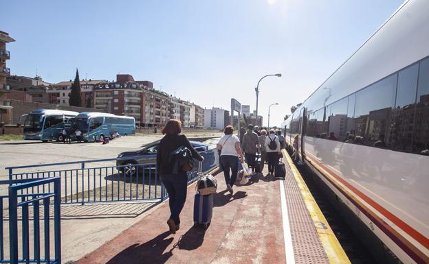 Pasajeros montando en el tren Madrid-Badajoz tras bajarse del autobús en la estación de Talavera. :