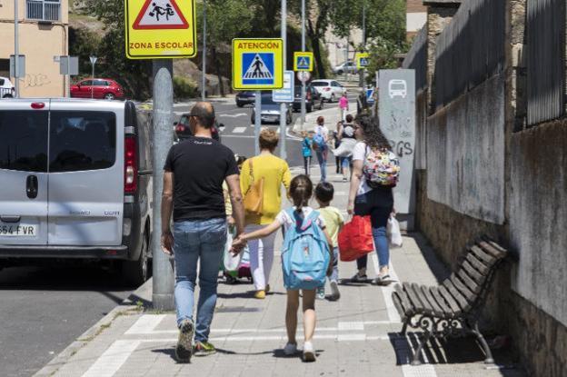 Escolares con sus padres a la salida de un colegio placentino. :: andy solé