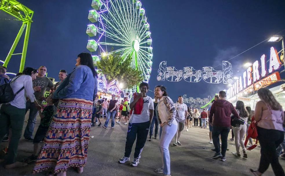 Numeroso público en el recinto ferial con la espectacular noria de fondo. ::