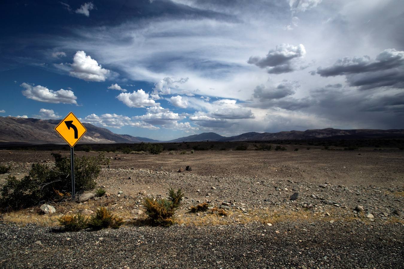 Imagen que muestra una señal de tráfico colindante a una carretera que atraviesa el Valle de la Muerte