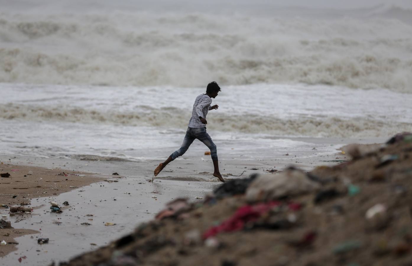 Los pescadores se preparan sacando los botes del mar arábigo ante la pronta llegada del ciclón Vayu a Veraval (india)