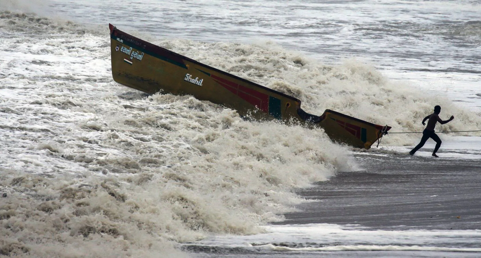 Los pescadores se preparan sacando los botes del mar arábigo ante la pronta llegada del ciclón Vayu a Veraval (india)