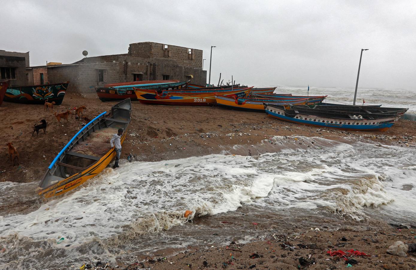 Los pescadores se preparan sacando los botes del mar arábigo ante la pronta llegada del ciclón Vayu a Veraval (india)