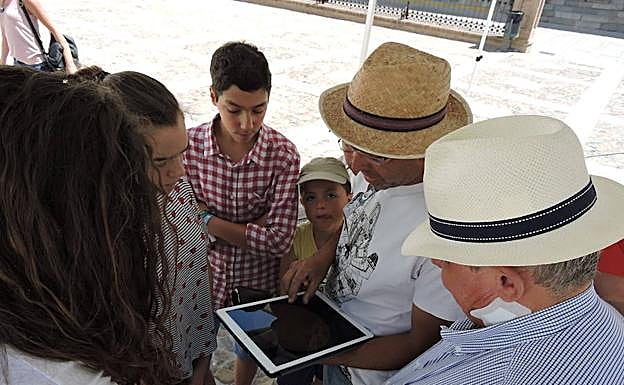 Imagen principal - Arriba recibiendo explicación en la tablet, abajo personas observando el sol