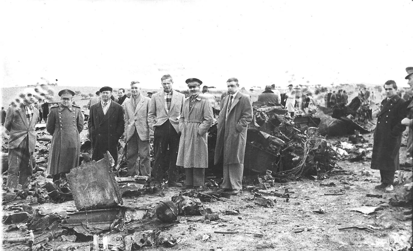 Imagen de los cinco tripulantes, junto a dos autoridades, en los restos del avión que cayó en las afueras de Cáceres.