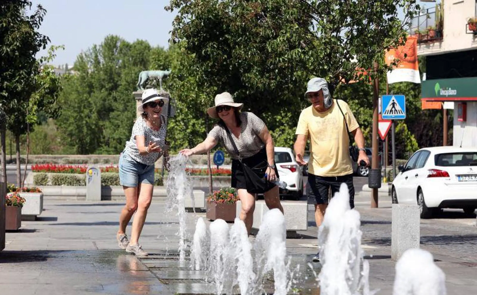 Un grupo de turistas en Mérida se refrescan en una fuente. Se han alcanzado los 41,2 grados. 