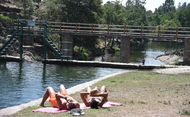 Dos bañistas toman el sol y pasan el rato en la piscina natural del Jevero.