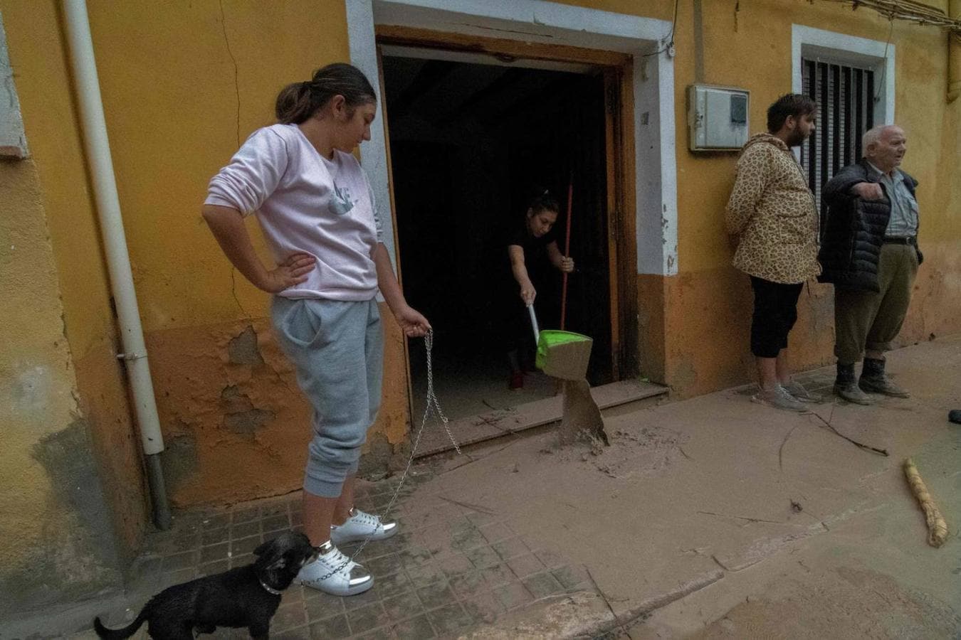 Una mujer saca el barro y el agua que ha inundado su casa, en Ontinyent (Valencia).