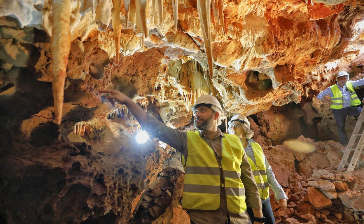 El alcalde, Luis Salaya, muestra a la consejera de Movilidad, Leire Iglesias, una de las estalactitas de la cueva del Carrucho. 