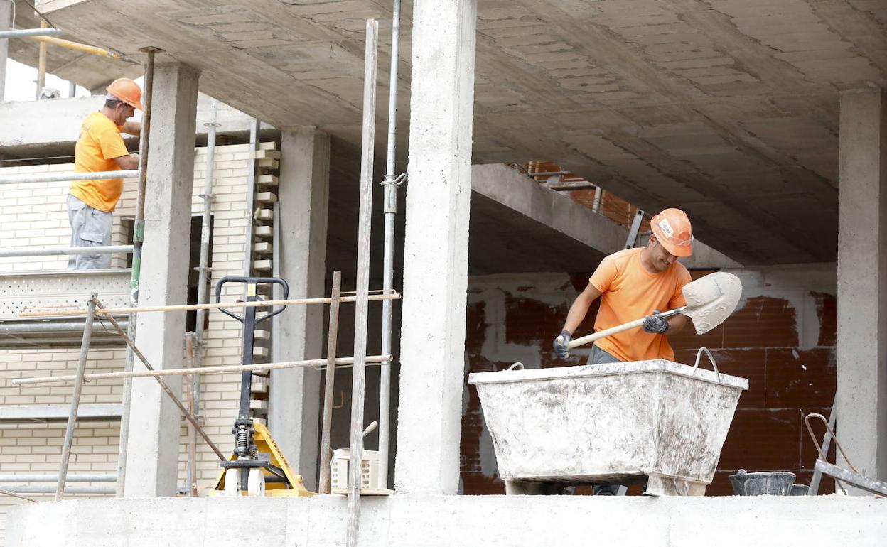 Dos obreros trabajando en la construcción de varias viviendas de nueva promoción en Cáceres. 