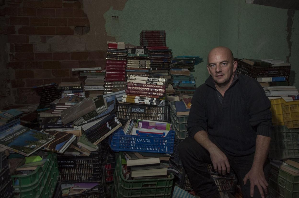 Carlos Díaz en un rincón del almacén donde guarda los libros que quiere donar. :: pakopí