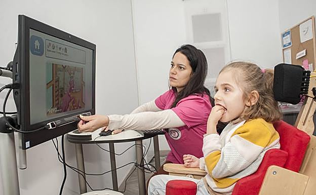 Sala de psicomotricidad. Ángela es una princesa Rett. Entrena con un ordenador (Tobii) para aprender a comunicarse. Sus ojos funcionan como el ratón para elegir lo que quiere ver, escuchar o comer:: PAKOPÍ