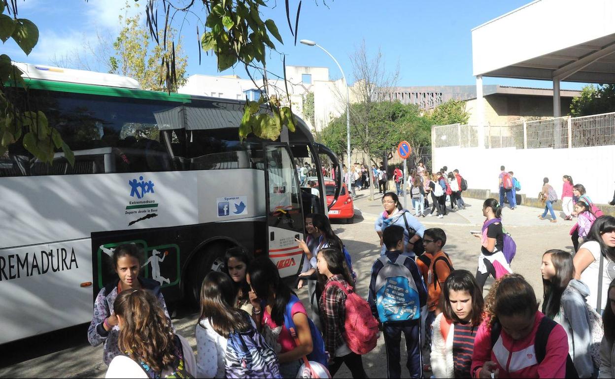 Estudiantes acceden a un autobús de una ruta de transporte escolar. 