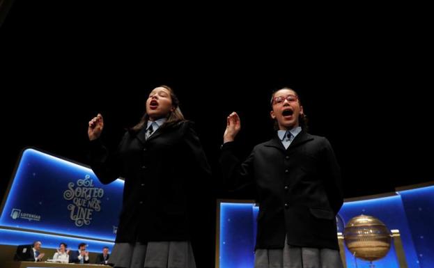 Las niñas del colegio de San Ildefonso Noura Akrouh (d) y Elizabeth del Carmen Roque (i) cantan el Gordo.