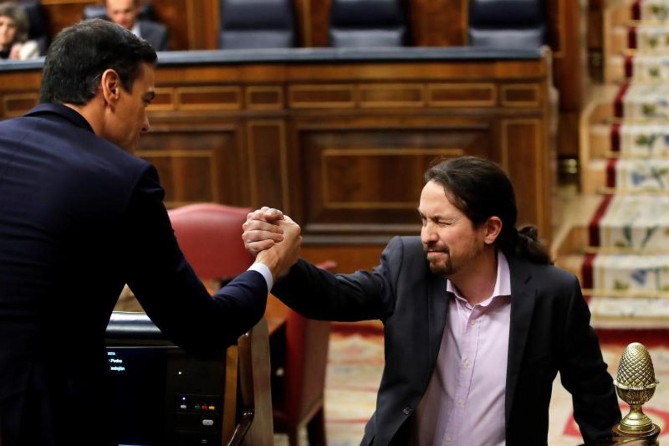 Iglesias choca la mano con Sánchez tras intervenir desde la tribuna y alabar la coalición entre PSOE y Unidas Podemos