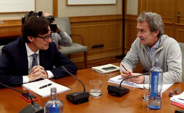 El ministro de Sanidad, Salvador Illa (i), conversa con el director del Centro de Emergencias y Alertas Sanitarias del Ministerio de Sanidad, Fernando Simón (d).