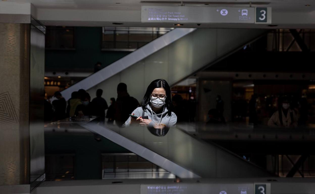 Una mujer con mascarilla, en un centro comercial en Hong Kong.