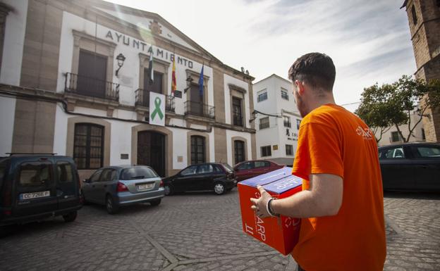 Un operario de una empresa de productos desinfectantes llevando cajas con gel al Ayuntamiento.