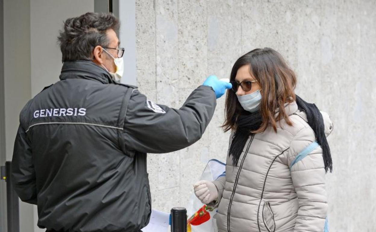 Personal verifica la temperatura de los clientes en la entrada de un supermercado cerca de Milán 