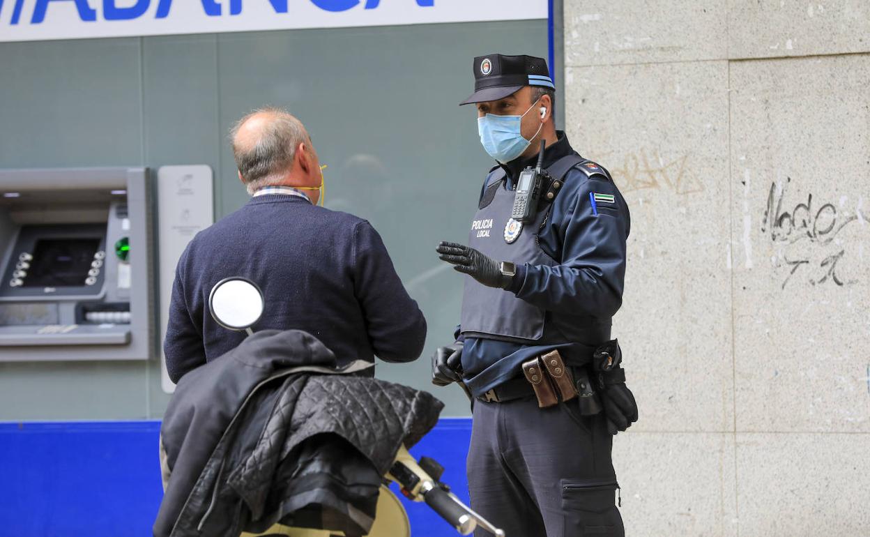 Un policía local dialoga con un ciudadano ayer por la mañana en la avenida de España. 