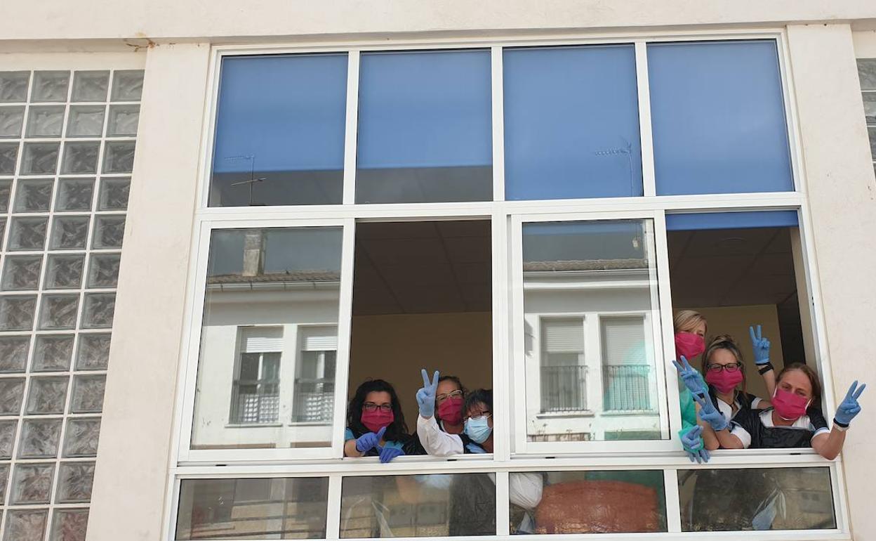 Empleadas de la residencia de mayores El Molino, en Torrequemada, saludando desde las ventanas.