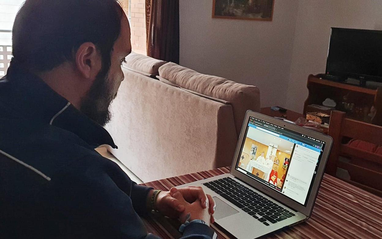 Uno de los fieles siguiendo la misa a través del ordenador. 